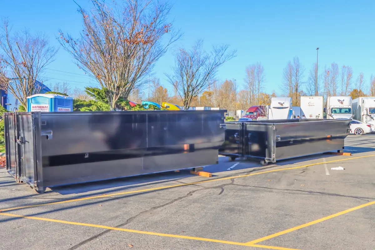 Professional dumpster rental service with roll-off container on residential driveway in Williston